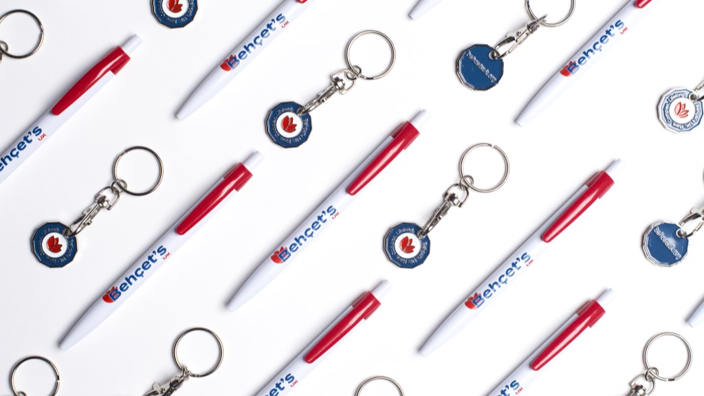 Photo shows some of the official Behçet's UK merchandise available - white pens and trolley token keyrings.