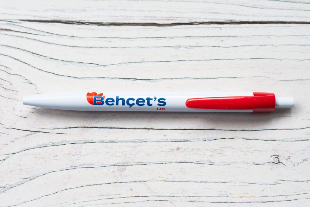 Close-up photo of a white plastic Behçet's UK pen