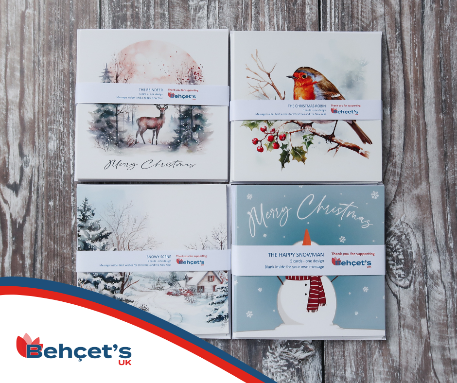 Photograph of our four Christmas card designs on a table: reindeers, robins, a snowy scene and a happy snowman. 