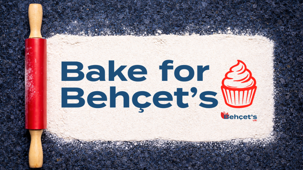 A red rolling pin on a dark countertop rolling out a rectangle of white flour with the text ‘Bake for Behçet’s’ in bold blue letters, accompanied by a red cupcake illustration and the Behçet’s UK logo in the corner